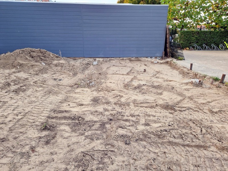 Kale zandvlakte in een achtertuin, de bouwplek voor een tuinkamer