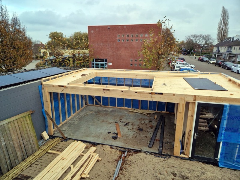 Tuinkamer in aanbouw met houten dakconstructie en een opening in het dak
