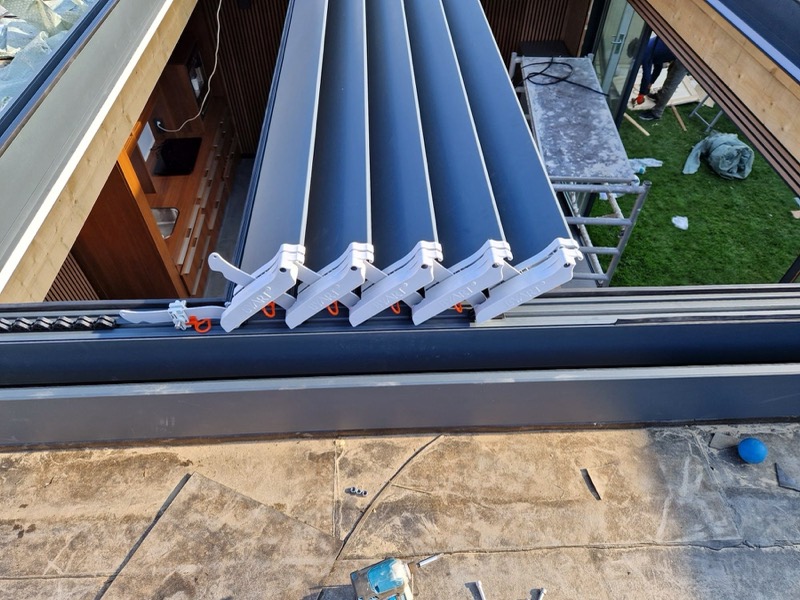 Montage van aluminium lamellen in de dakopening van een tuinkamer
