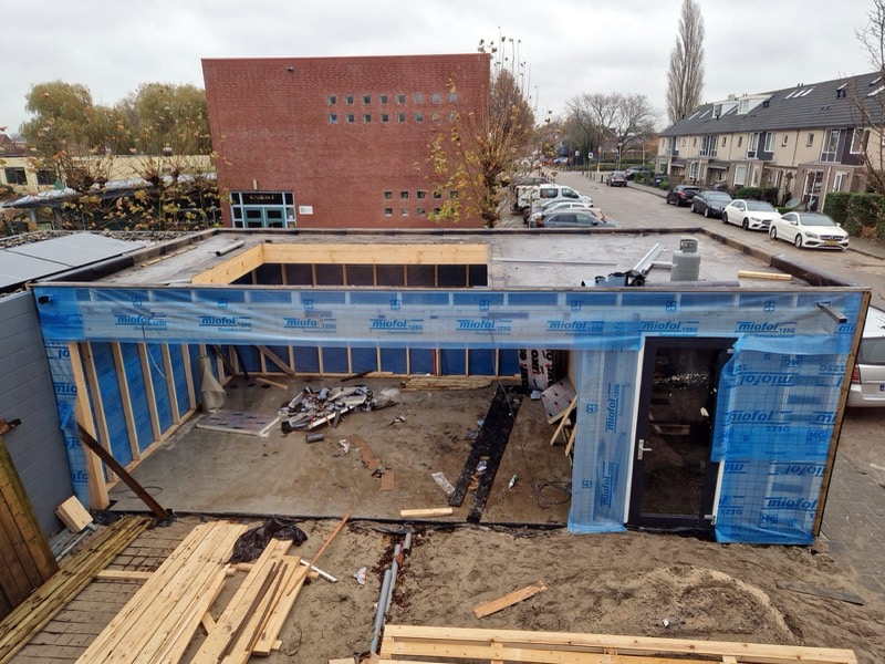 Tuinkamer in aanbouw van bovenaf, ingepakt in folie met het dak erop