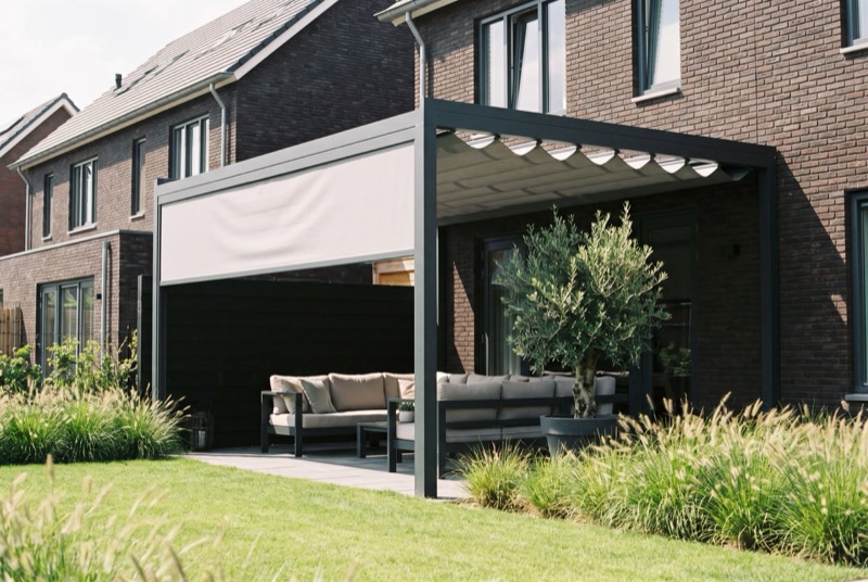 Vrijstaande witte pergola met half ingeschoven doekdak boven een eettafel