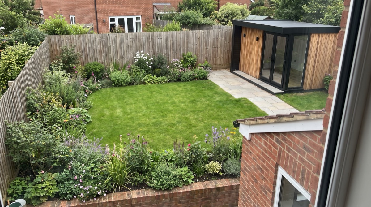 Overzicht van een Nederlandse achtertuin met tuinkamer achterin