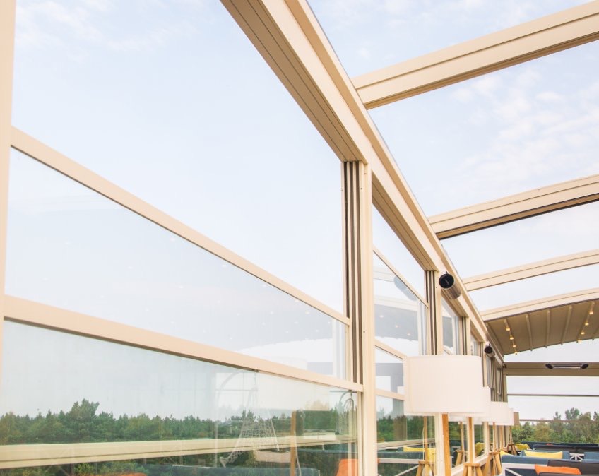 Glazen schuifwanden rond een terras met uitzicht op de tuin